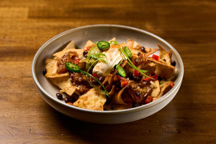 Delicious meat nachos featuring seasoned beef, melted cheese, and fresh garnishes, perfect for sharing.